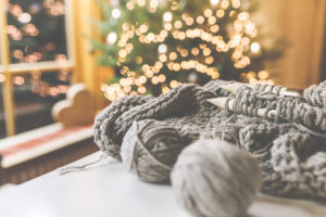 Gemütliches Weihnachten mit schöner Beleuchtung und dem Strickzeug mit großen Nadeln und schöner Wolle. Gemütliches Weihnachten mit schöner Beleuchtung und dem Strickzeug mit großen Nadeln und schöner Wolle.